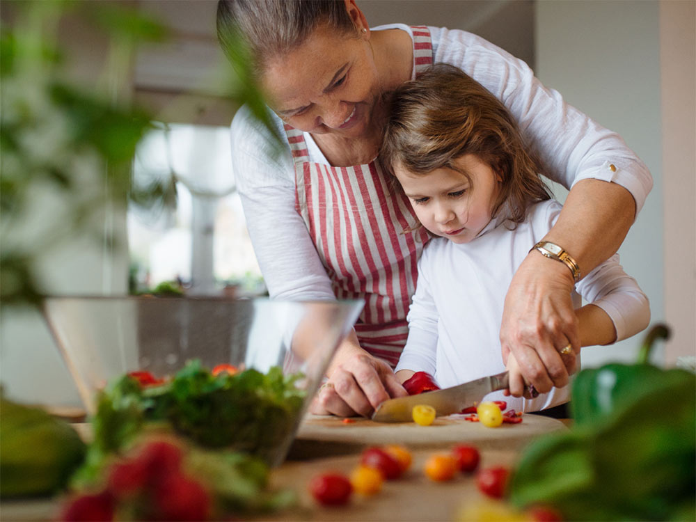 Kvinde laver mad med barn i lavenergi bolig